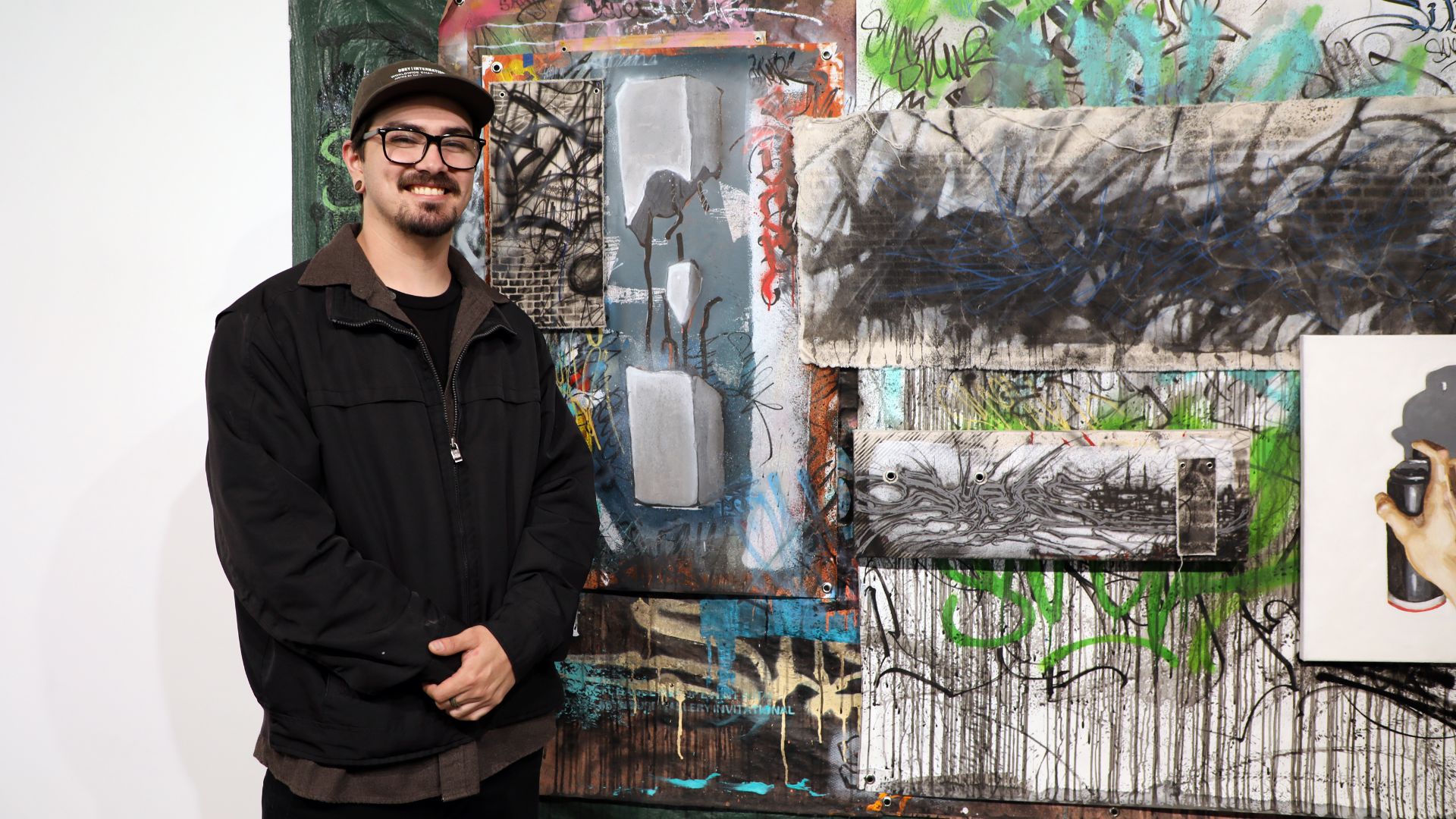 Norco College alum Jonathan Godinez in front of his artwork