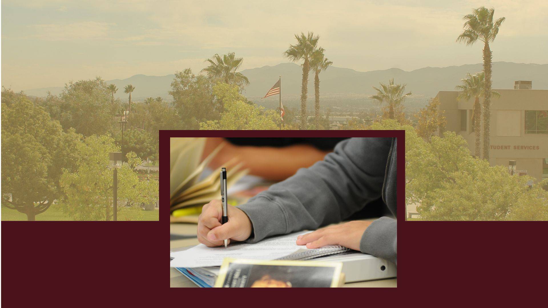 Image of Honors Class student's hand writing on paper, behind image of campus