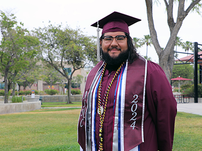 Jose Orozco on Norco College campus in commencement regalia Jose Orozco on Norco College campus in commencement regalia